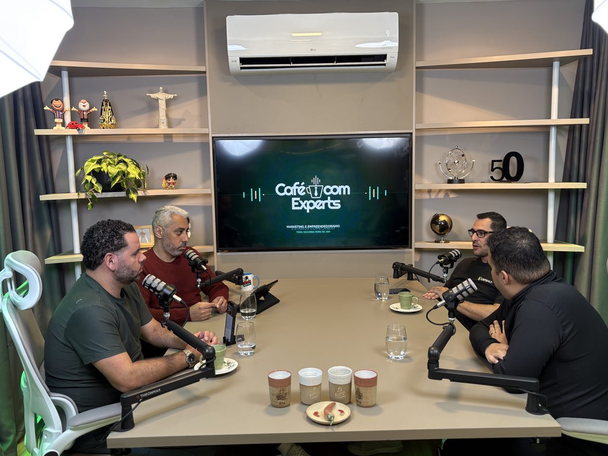 Plano largo: a mesa inteira em uso, e quem fotografa também aparece.