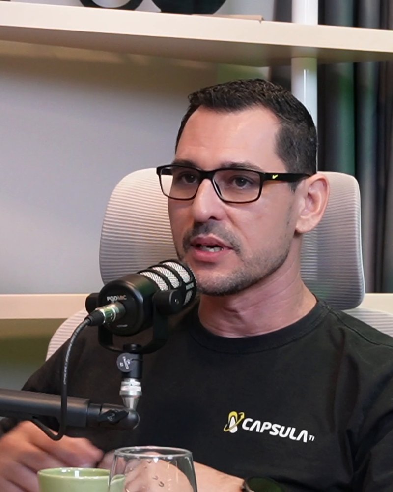 César Munutti falando ao microfone, na mesa do estúdio.